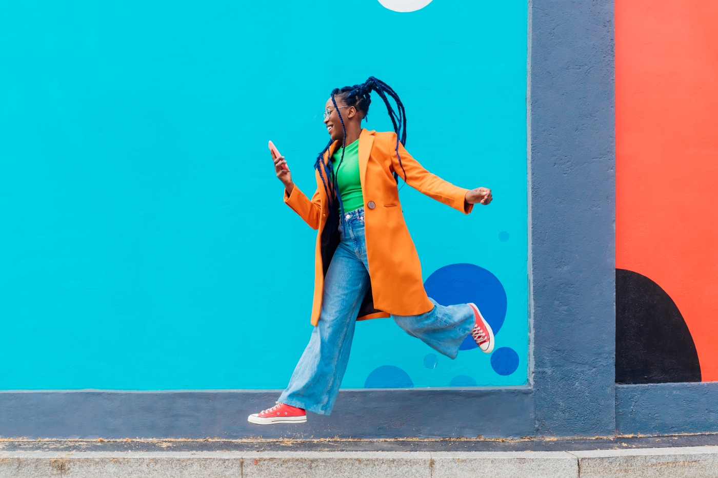 Girl jumping in front of blue wall